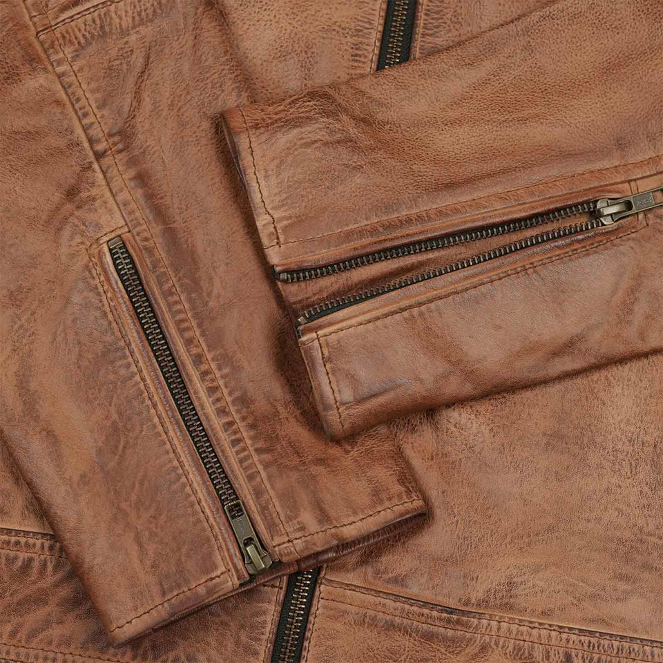 Close-up of the YKK zippers and quilted black inner lining on the cowhide leather jacket, highlighting premium craftsmanship and design
